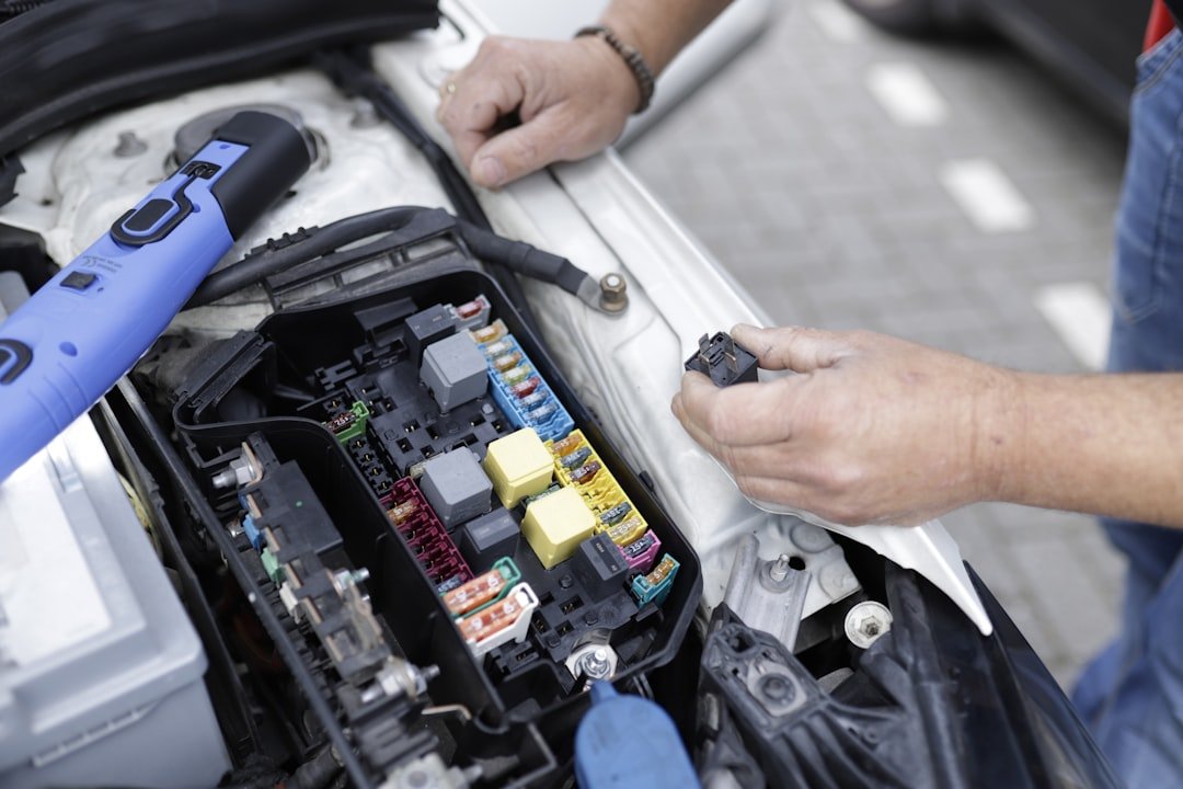 Car mechanic working on a cars electronics.